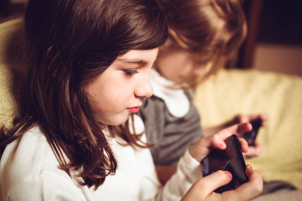 Malé dívky hrají hry na svých mobilních telefonech - Fotografie, Obrázek