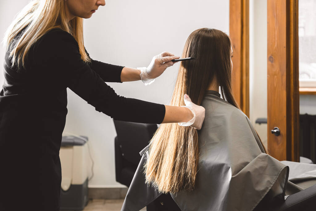 Maestro peluquero peina el cabello de las niñas después de lavar y antes de peinar en un salón de belleza. - Foto, Imagen