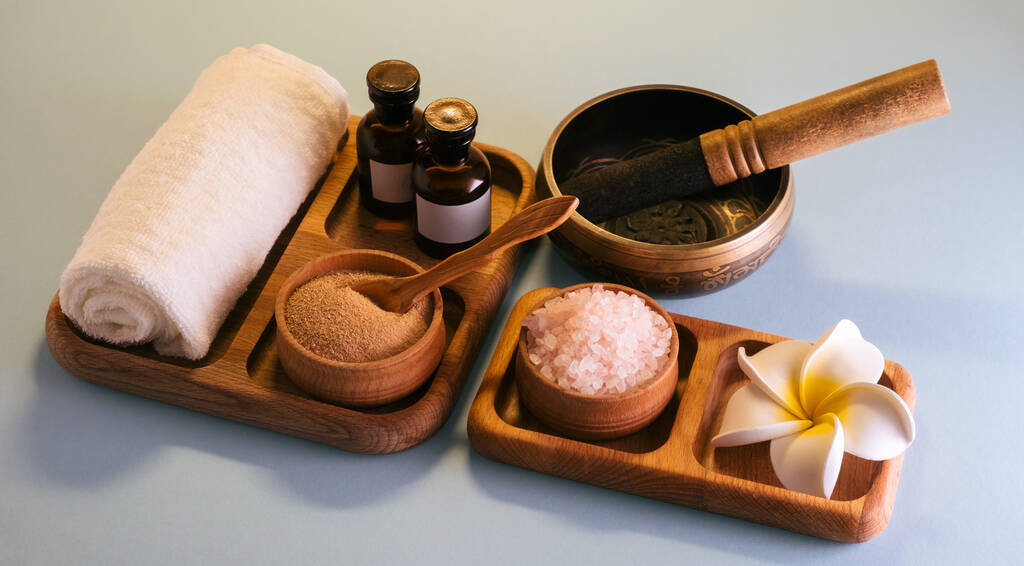 Set spa avec bol chantant, huiles, sel de mer et gommage à l'argile sur un plateau en bois. Concept d'autosoin. - Photo, image