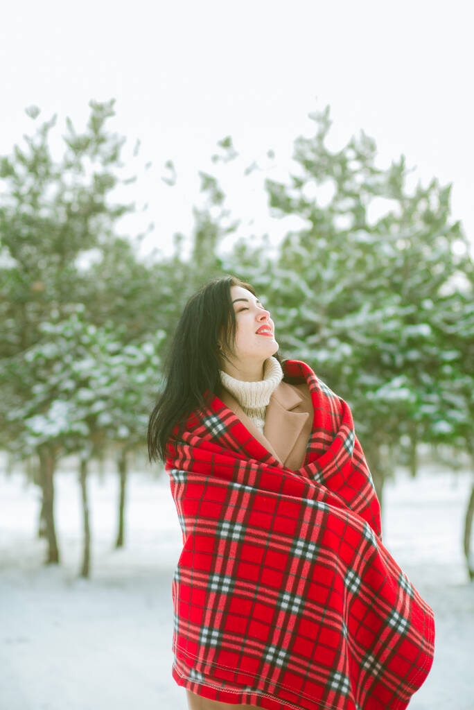 赤いスカーフに黒い髪の若いかわいい女の子は公園で冬の雪の天気で楽しいです。ライフスタイル  - 写真・画像