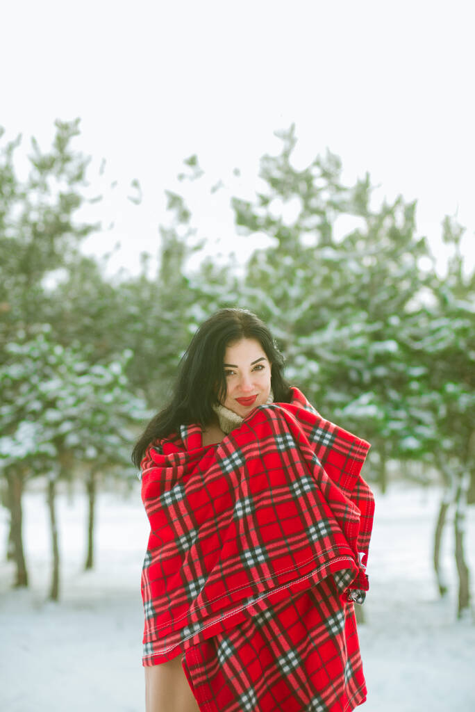 Fiatal aranyos lány durk haj piros sál szórakozik havas időben télen a parkban. Életstílus  - Fotó, kép