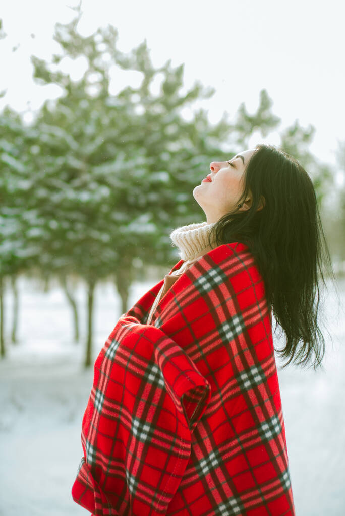 赤いスカーフに黒い髪の若いかわいい女の子は公園で冬の雪の天気で楽しいです。ライフスタイル  - 写真・画像