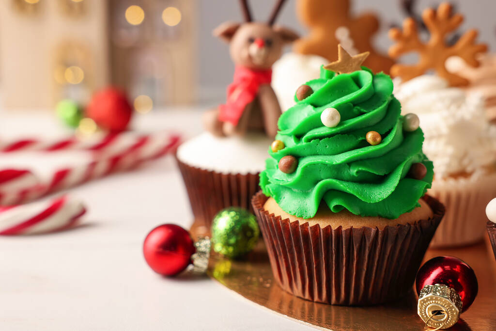 Ízletes karácsonyfa muffin és baubles a fehér asztalon. A szöveg helye - Fotó, kép