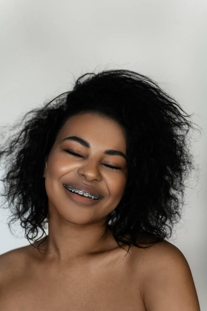 歯に歯のブレースを持つ笑顔の黒人女性の肖像画  - 写真・画像
