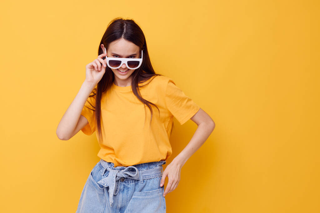 beautiful girl with long hair wearing sunglasses posing yellow background - Photo, Image