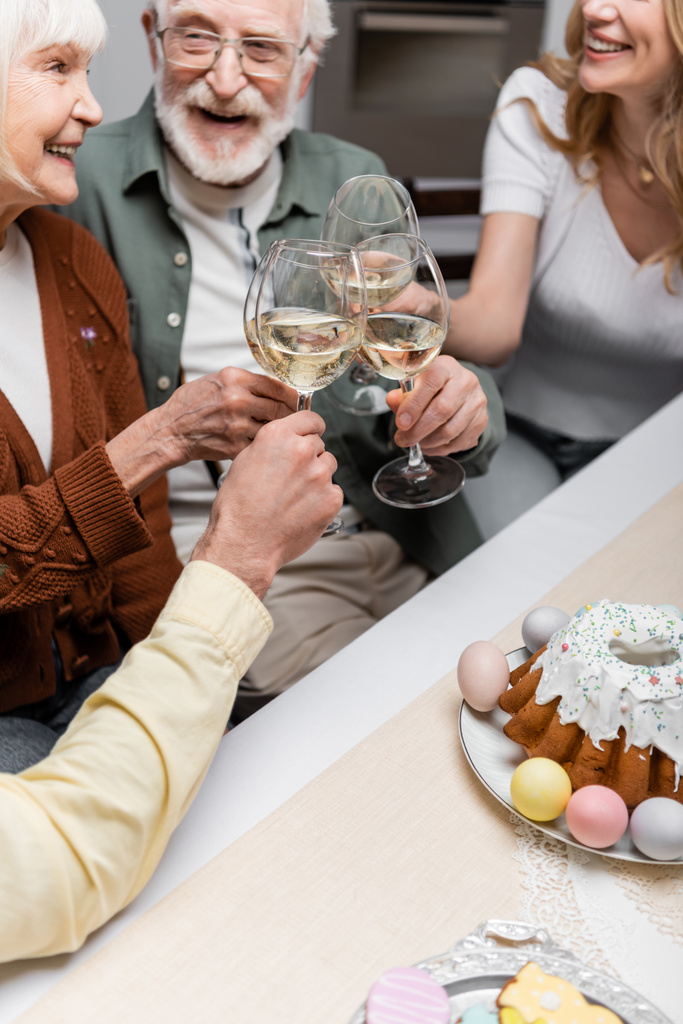 пожилая пара звон бокалы вина во время празднования Пасхи со взрослыми детьми - Фото, изображение
