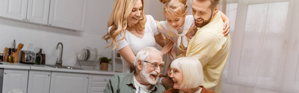 взволнованная девочка веселится с родителями возле бабушки и дедушкой дома, баннер - Фото, изображение