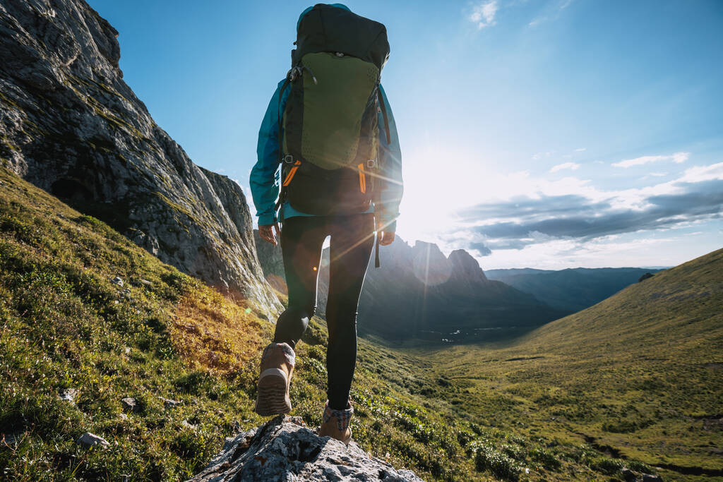 Solo woman backpacker hiking on alpine mountain peak - Φωτογραφία, εικόνα