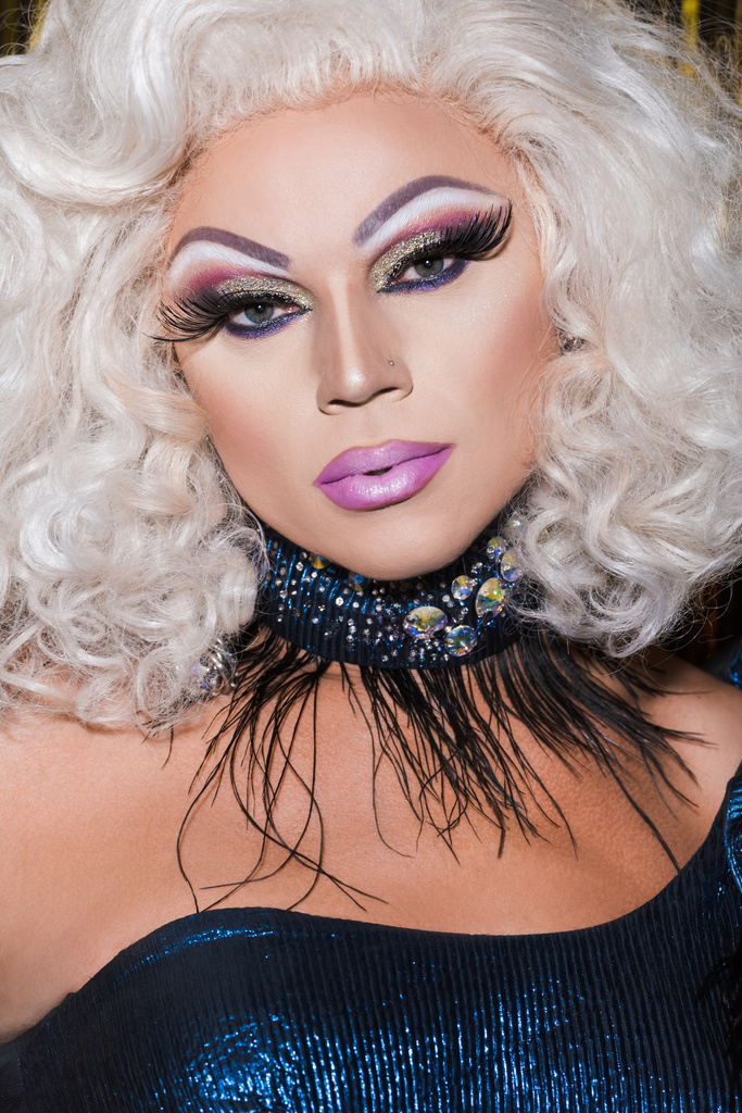 portrait de drag queen avec maquillage lumineux, en perruque blonde et collier à paillettes - Photo, image