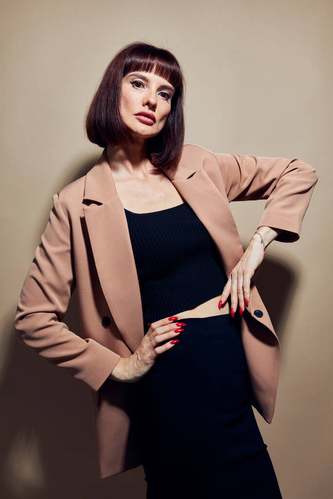 ベージュのジャケットの魅力的な女性エレガントなスタイルのポーズライフスタイル変更なし - 写真・画像