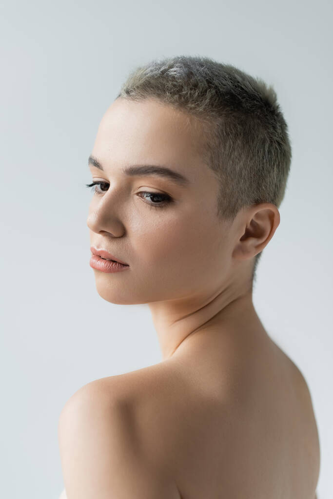 young woman with short hair and naked shoulders isolated on grey - Photo, Image