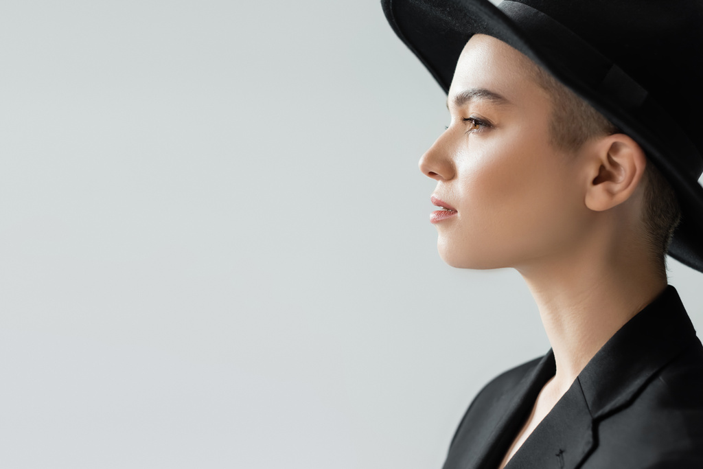 Seitenansicht einer Frau mit schwarzem Hut mit Krempe isoliert auf grau mit Kopierraum - Foto, Bild