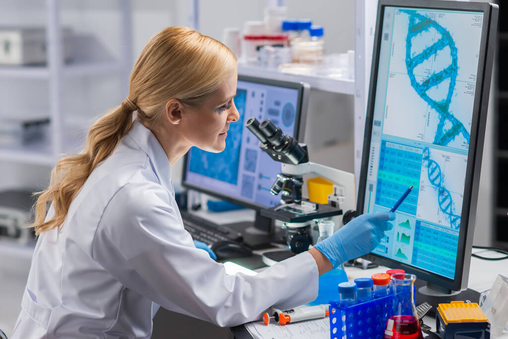 Professionele vrouwelijke wetenschapper werkt aan een vaccin in een modern wetenschappelijk onderzoekslaboratorium. Genetische ingenieur werkplek. Toekomstige technologie en wetenschap. - Foto, afbeelding