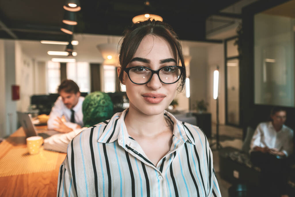 Porträt einer Geschäftsfrau in lässiger Kleidung mit Brille im modernen Großraumbüro eines Start-ups. Selektiver Fokus. Hochwertiges Foto - Foto, Bild