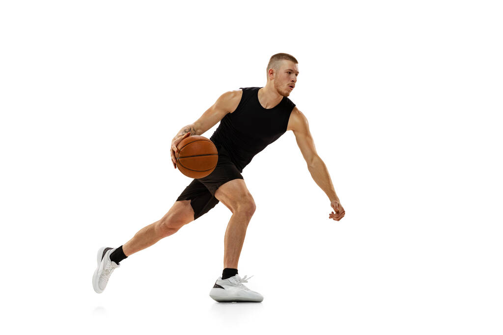 Jonge gespierde man, basketbalspeler oefenen met bal geïsoleerd op witte studio achtergrond. Sport, beweging, activiteitsconcepten. - Foto, afbeelding