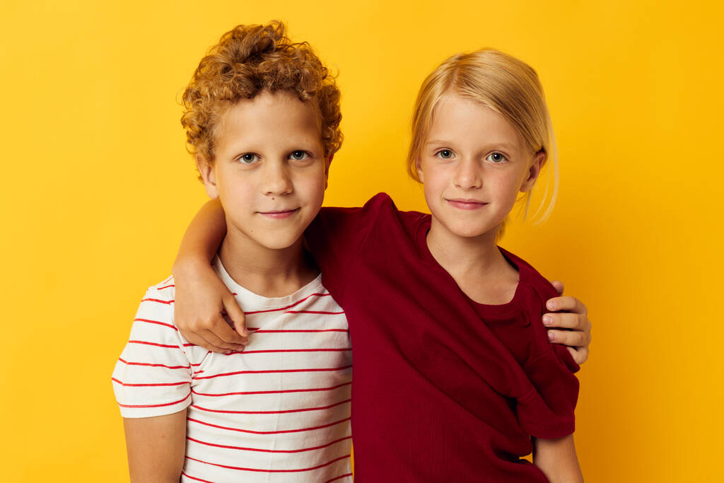 Αγόρι και κορίτσι αγκαλιά μόδα παιδική διασκέδαση κίτρινο φόντο - Φωτογραφία, εικόνα