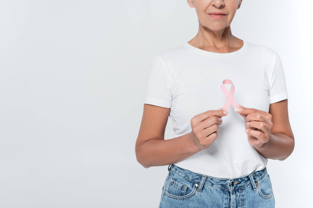 Widok starszej kobiety trzymającej różową wstążkę świadomości raka piersi odizolowanej na szaro  - Zdjęcie, obraz