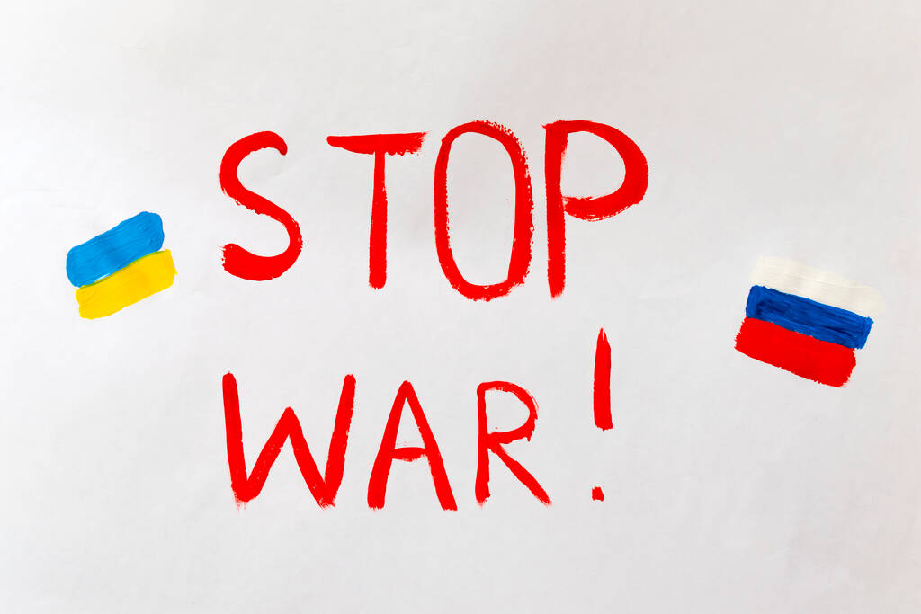 Le concept de mettre fin à la guerre en Ukraine. Coeur brisé dans les couleurs du drapeau de l'Ukraine et de la Russie entre les mains des femmes avec le texte que nous ne voulons pas la guerre - Photo, image