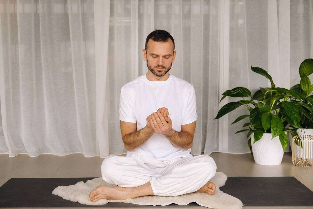 muž v bílém sportovním oblečení dělá jógu s posilovnou. koncept zdravého životního stylu. - Fotografie, Obrázek