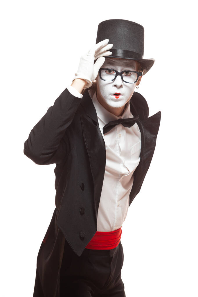 Porträt eines männlichen Pantomimen, der isoliert auf weißem Hintergrund auftritt. Mime hält seinen Hut in der Hand und blickt überrascht in die Kamera - Foto, Bild