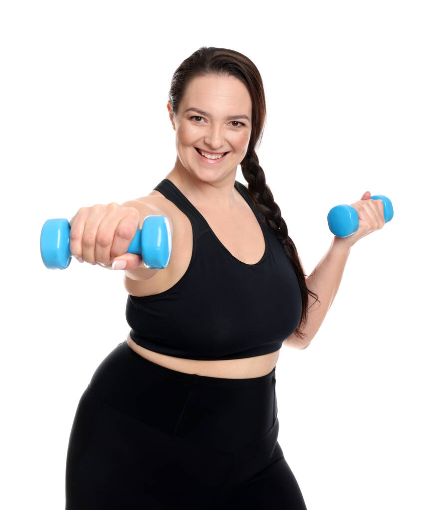 Mujer feliz con sobrepeso haciendo ejercicio con pesas sobre fondo blanco - Foto, Imagen