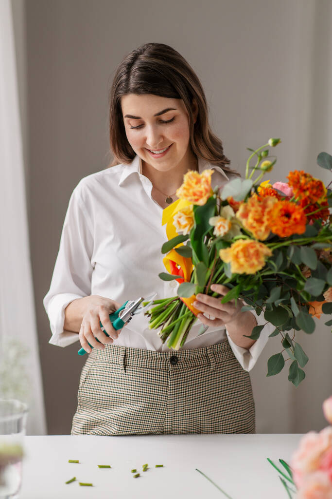 счастливая женщина, делающая букет цветов дома - Фото, изображение