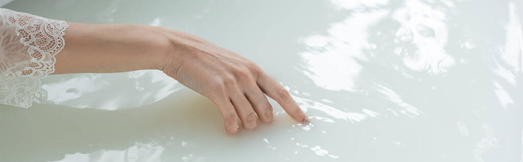 Vista ritagliata della donna che tocca l'acqua nella vasca da bagno, banner  - Foto, immagini