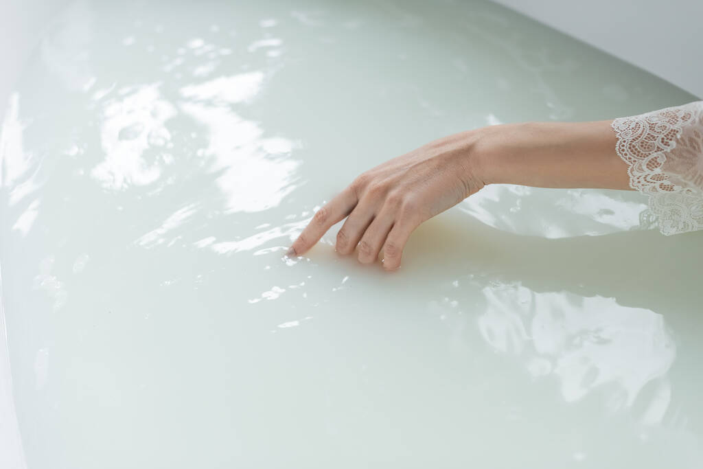 Banyodaki küvette suya dokunan kadın görüntüsü.  - Fotoğraf, Görsel