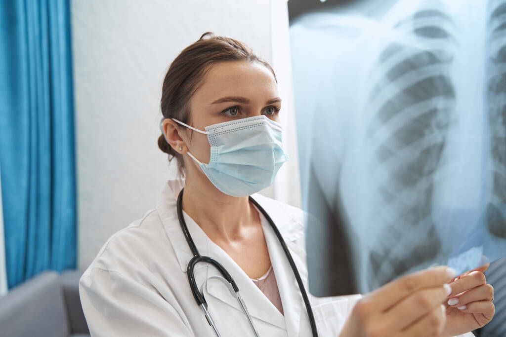 Lääkäri naamio katsot rinnassa röntgenkuva - Valokuva, kuva