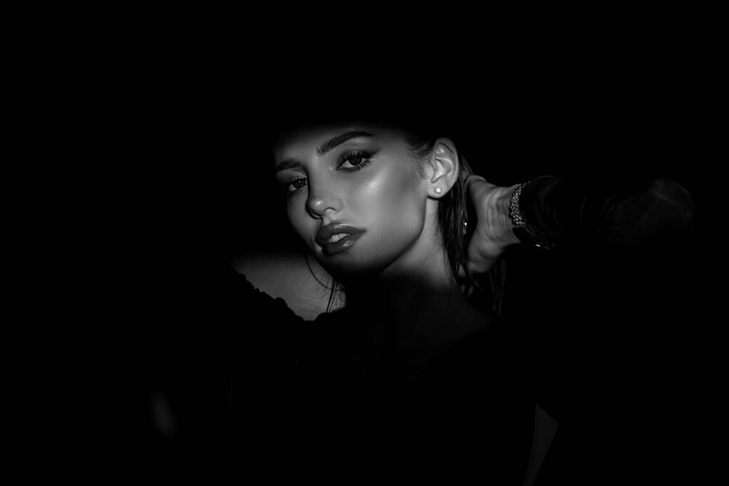 Woman in shadow. Female model with shadows on face looking seductive and sensual on dramatic black studio with light. Dramatic light on sensual seduction woman face. - Foto, immagini