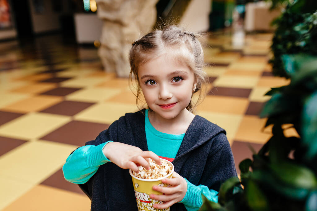 meisje met kop popcorn in park - Foto, afbeelding