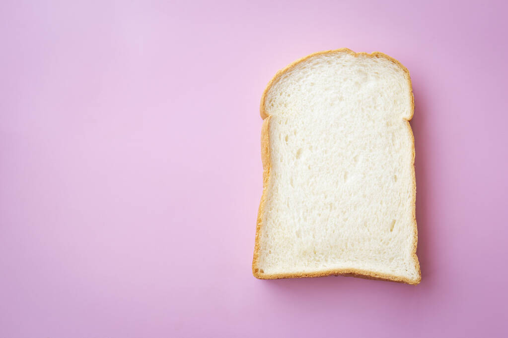 Dünne Scheiben Brot auf rosa Hintergrund. - Foto, Bild