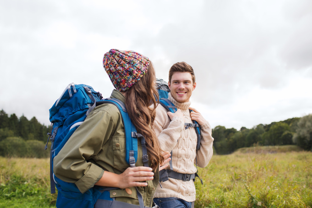 smiling couple with backpacks hiking - Photo, Image