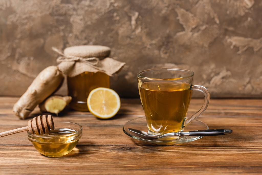 Herbata i miód w misce na drewnianej powierzchni na teksturowanym tle kamienia  - Zdjęcie, obraz