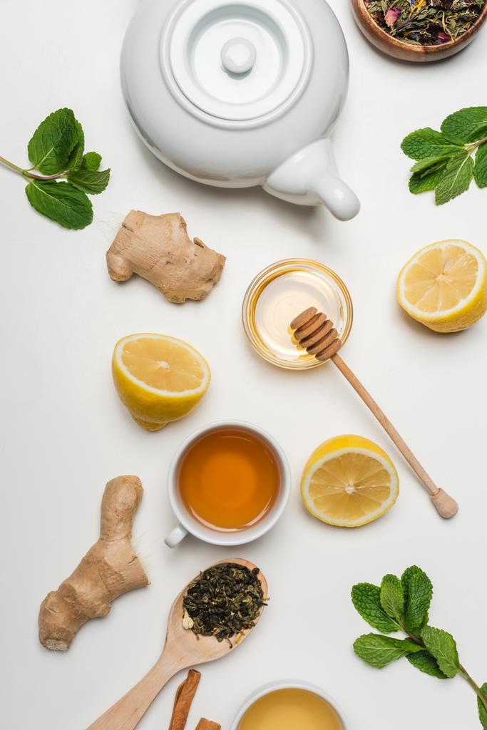 Вид зверху чашки чаю біля меду та м'яти на білому тлі
  - Фото, зображення