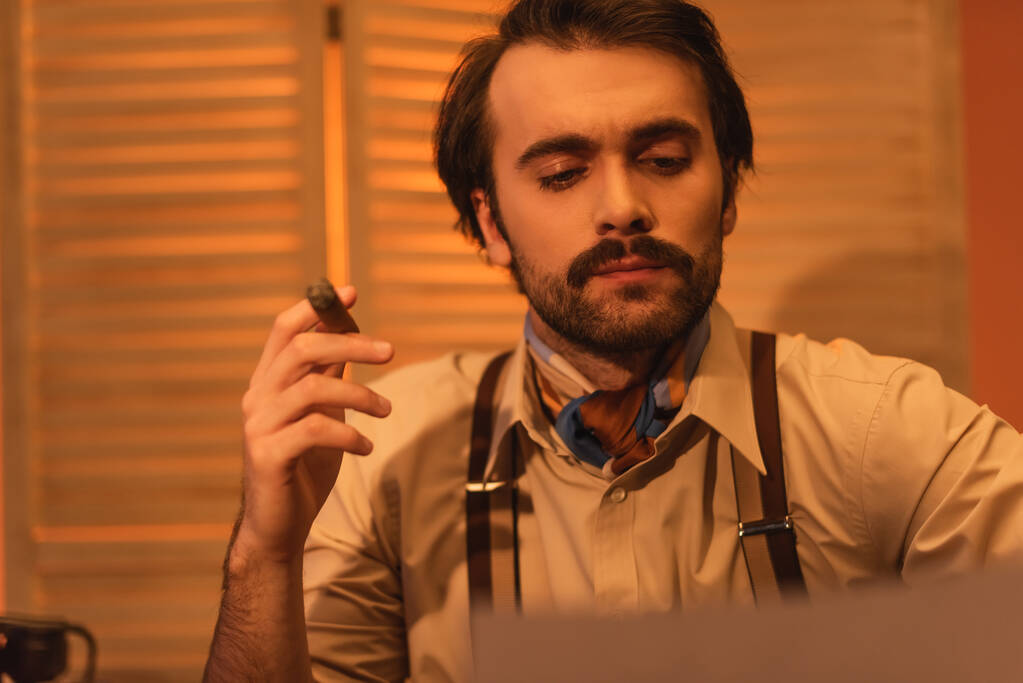 hombre con bigote mirando papel y sosteniendo cigarro  - Foto, Imagen