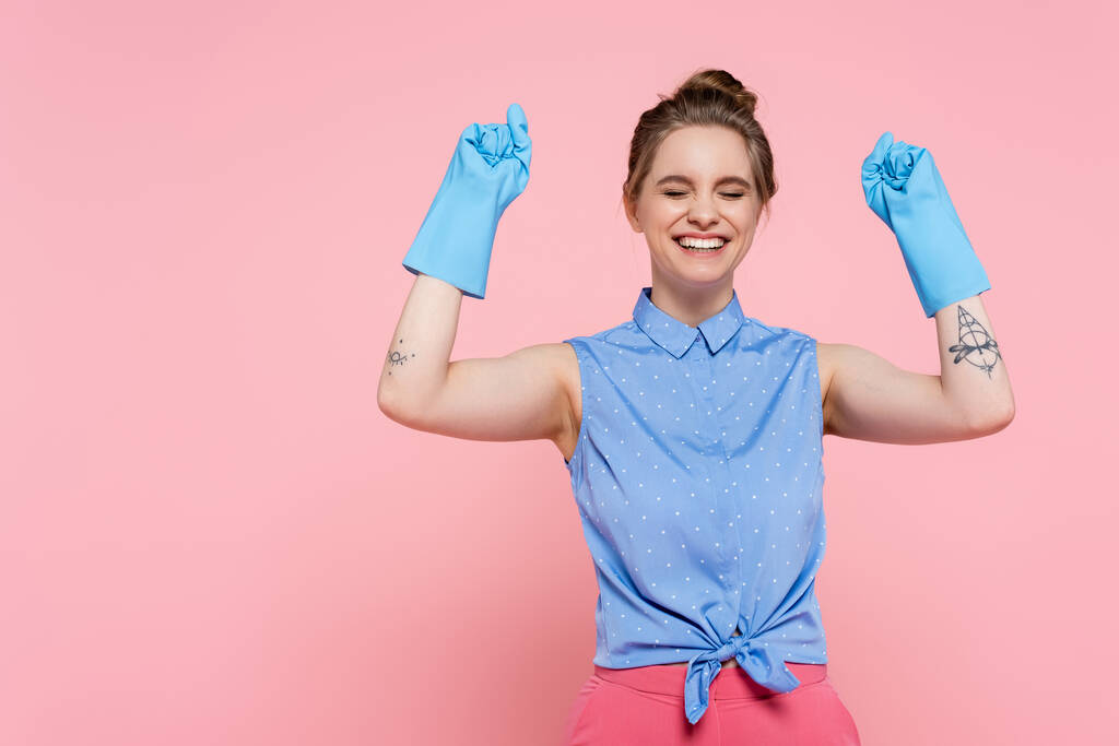 興奮し入れ墨をした女性はピンクに隔離されたゴム手袋で  - 写真・画像