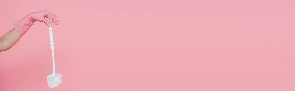 vista recortada de la mujer en guante de goma con cepillo de inodoro aislado en rosa, pancarta - Foto, imagen