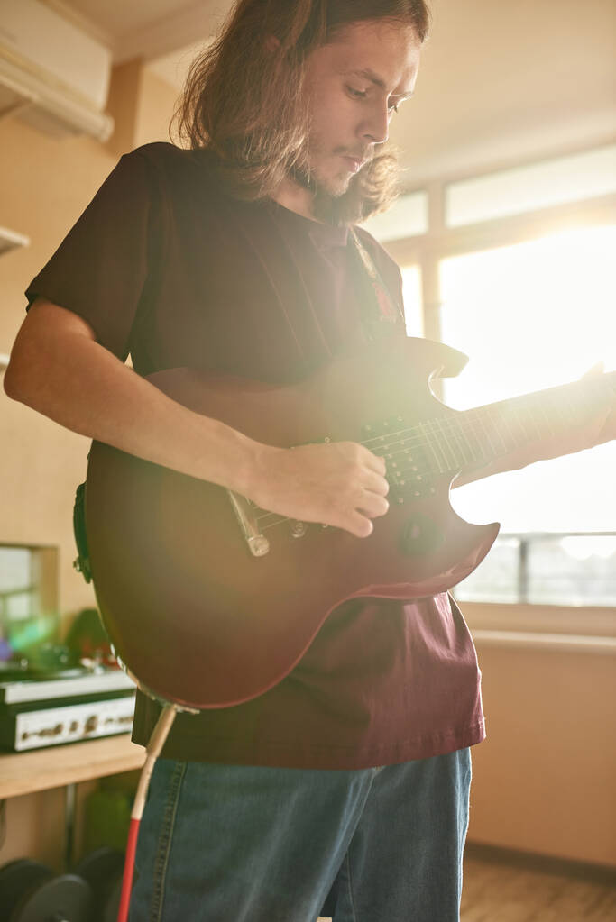 Músico enfocado tocando la guitarra eléctrica en casa - Foto, imagen