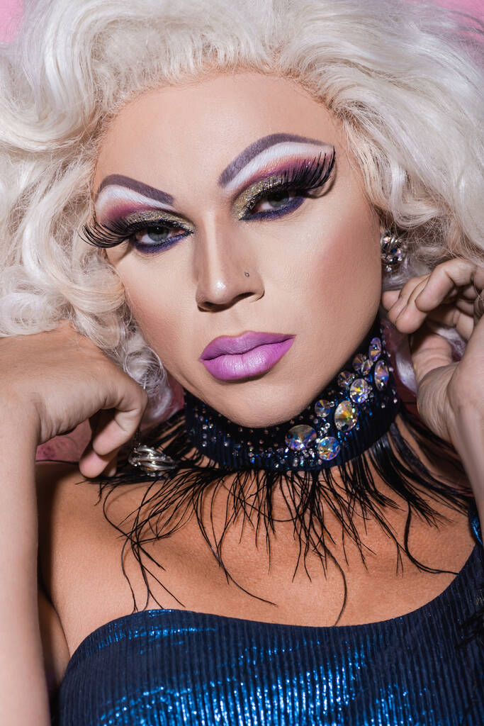 zblízka portrét drag queen v třpytivém náhrdelníku při pohledu do kamery - Fotografie, Obrázek