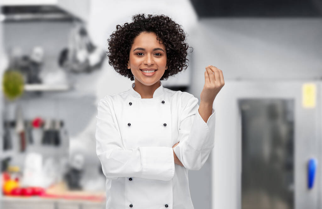счастливая женщина-шеф-повар, показывающая знак гурмана на кухне - Фото, изображение