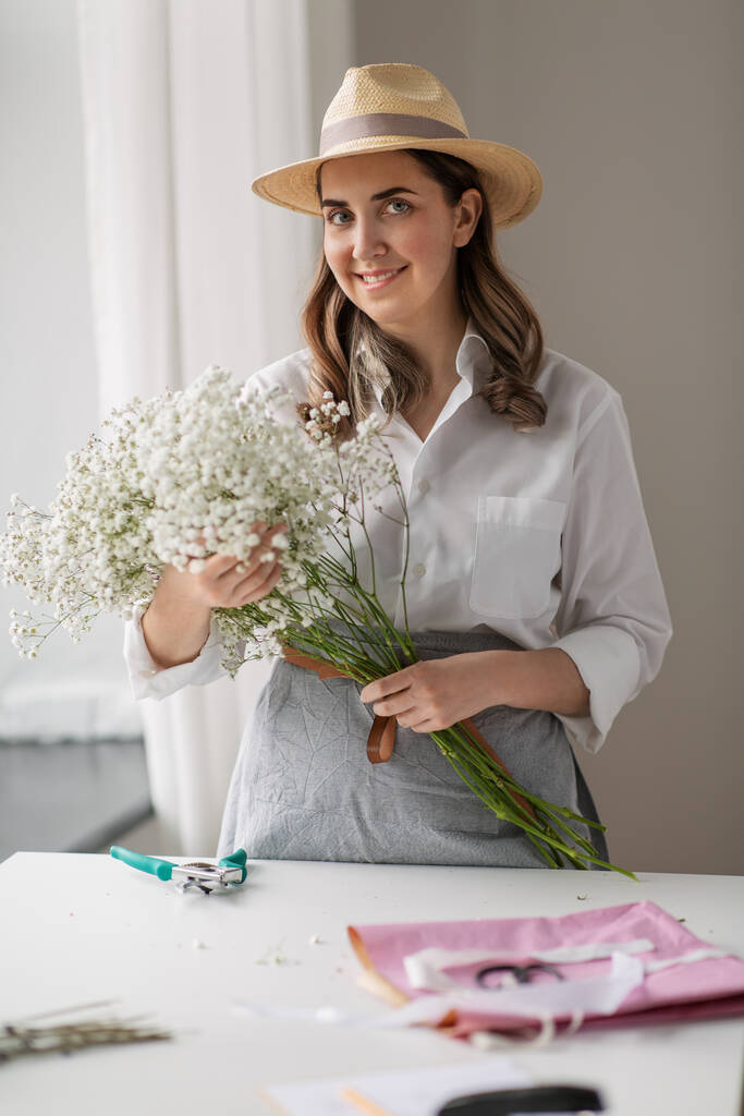Ευτυχισμένη γυναίκα με γυψόφυλλες λουλούδια στο στούντιο - Φωτογραφία, εικόνα