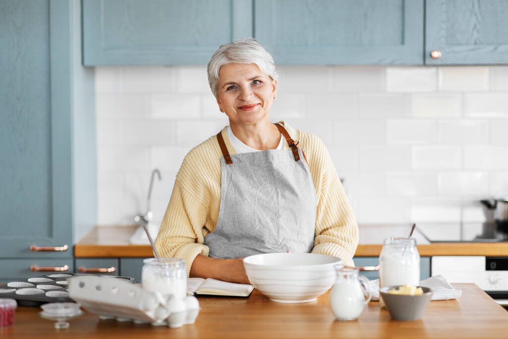 gelukkig vrouw koken eten op keuken thuis - Foto, afbeelding