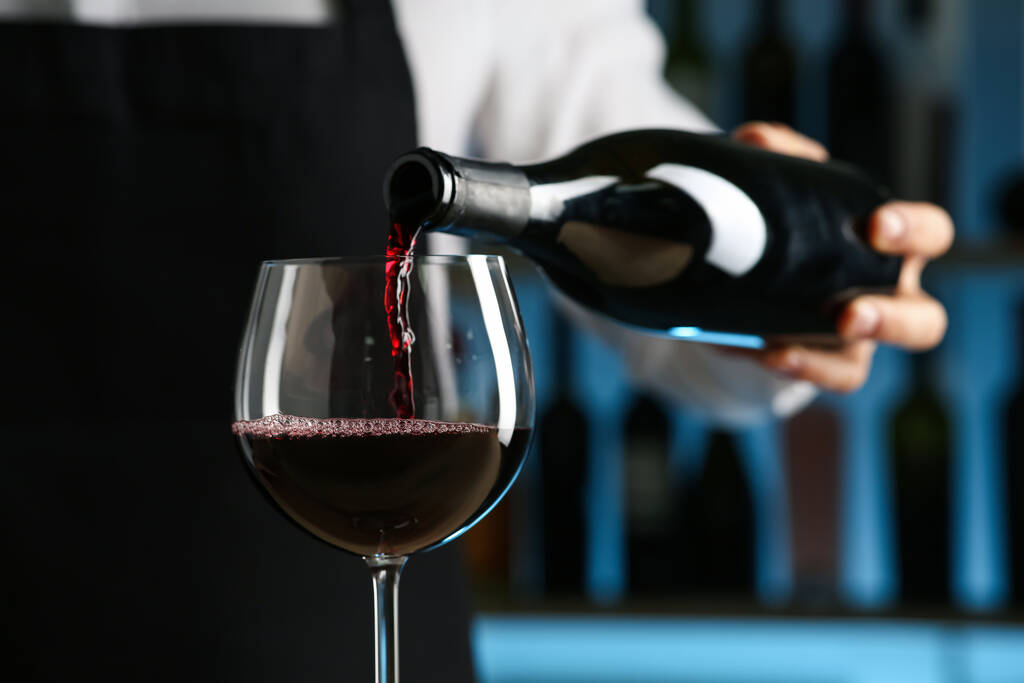 Μπάρμαν ρίχνει κρασί σε ποτήρι στο εστιατόριο, closeup - Φωτογραφία, εικόνα