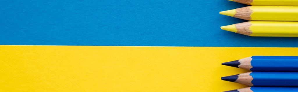 Horní pohled na žluté a modré tužky na ukrajinské vlajce, banner  - Fotografie, Obrázek