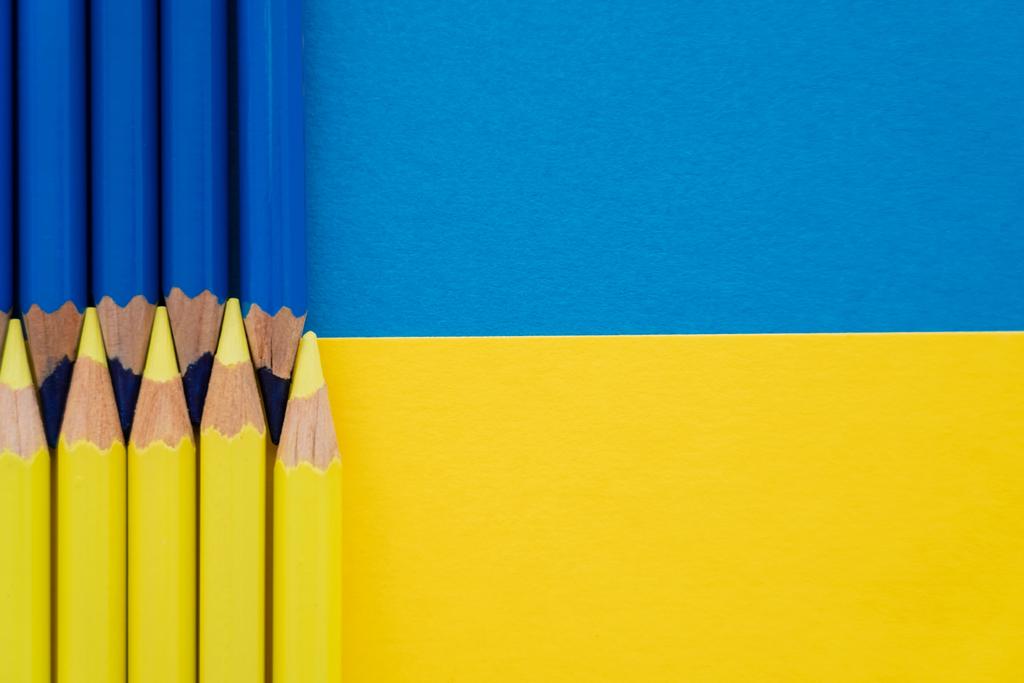 Vista dall'alto di matite di colore giallo e blu sulla bandiera ucraina con spazio copia  - Foto, immagini
