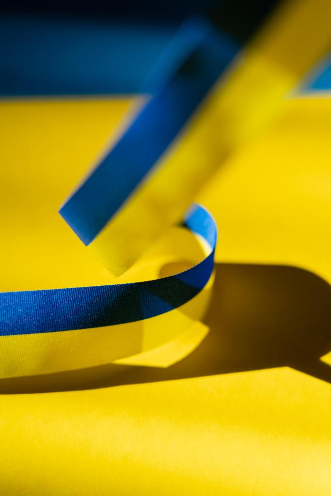 Nahaufnahme des verschwommenen blauen und gelben Bandes mit Schatten auf der ukrainischen Flagge - Foto, Bild