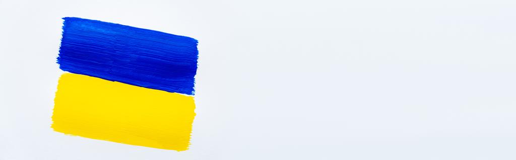 Widok z góry malowane niebiesko-żółta ukraińska flaga na białym tle, sztandar  - Zdjęcie, obraz