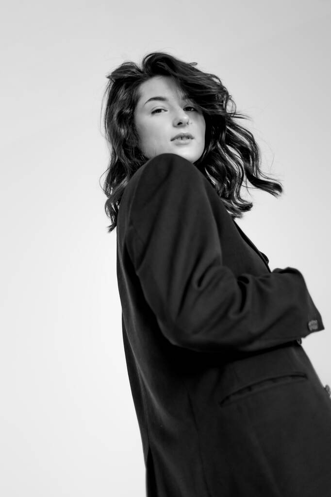 ritratto in bianco e nero di giovane donna elegante che indossa pantaloni larghi e giacca - Foto, immagini