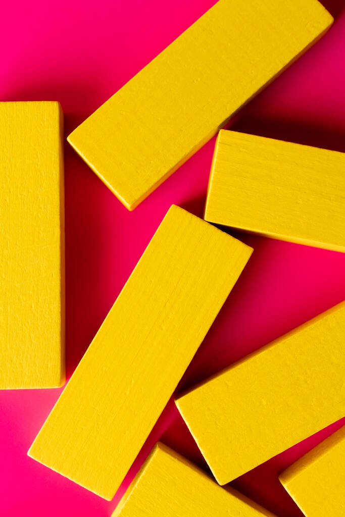 primer plano de bloques de color amarillo brillante sobre fondo rosa, vista superior - Foto, Imagen
